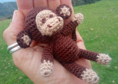 Little mini crochet monkey on the palm of the hand